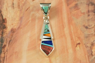 Genuine Turquoise, Spiny Oyster Shell, Magnesite and Blue Lapis inlaid in Sterling Silver. Free 18" Sterling Silver Chain with purchase of pendant. Designed by Navajo Artist Calvin Begay. Signed.